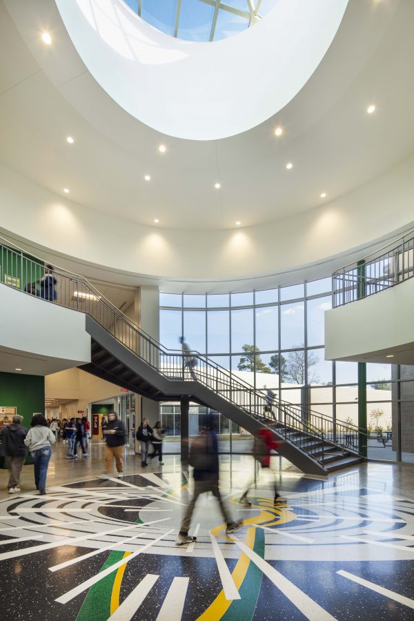 Two-story central rotunda connecting academic and student spaces at Mills University Studies High School.