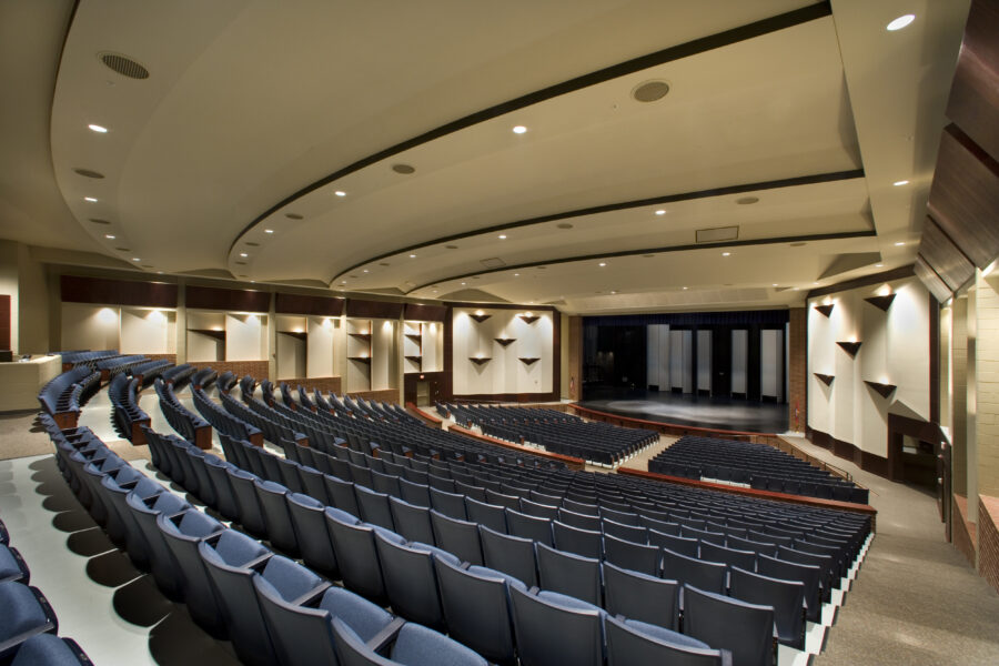 Professional theater stage inside Har-Ber High School Performing Arts Center with orchestra seating and proscenium stage