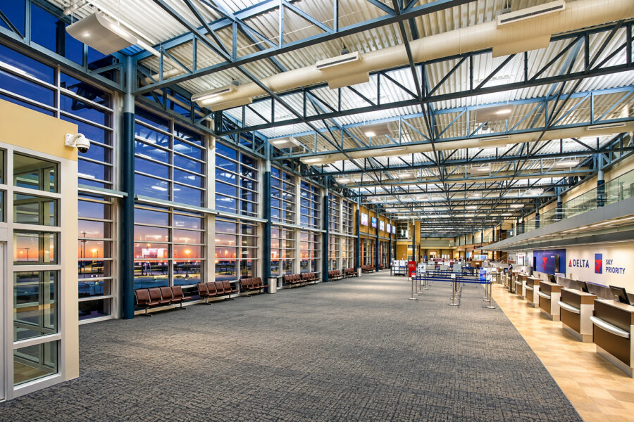 XNA terminal interior featuring exposed steel structure, large windows and passenger check-in areas