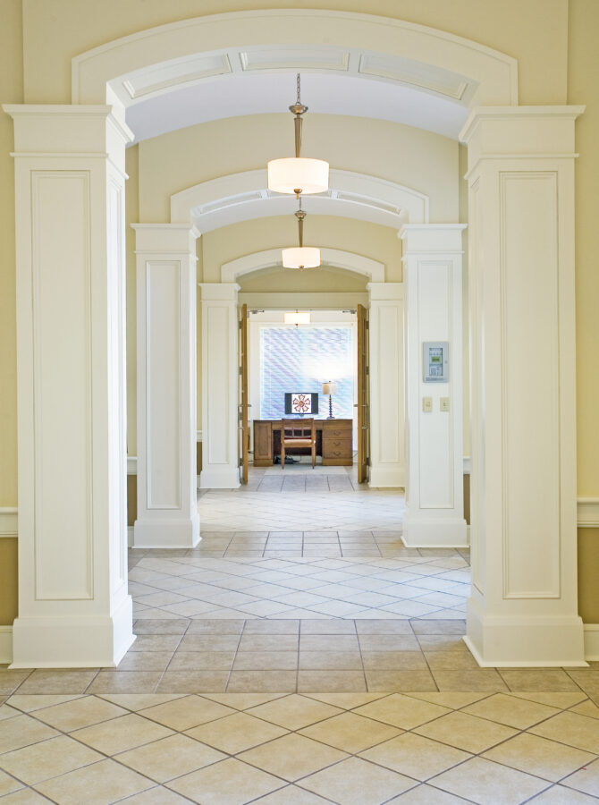 Interior corridor at the University of Arkansas Sigma Nu Fraternity House featuring arched openings and columns.