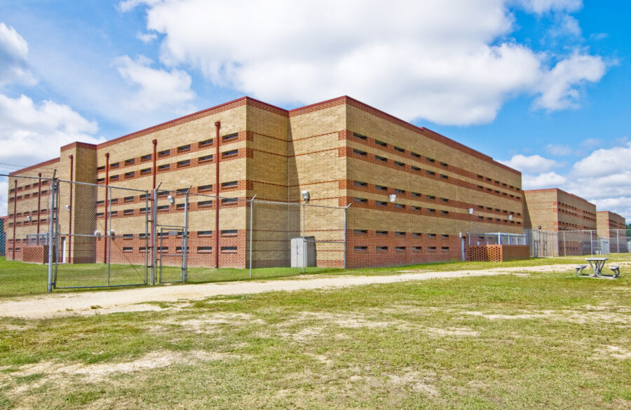 Secure housing buildings at the Arkansas Department of Correction Malvern Special Needs Unit in Malvern, Arkansas, designed by WDD Architects, featuring brick facades, narrow windows and perimeter security fencing.