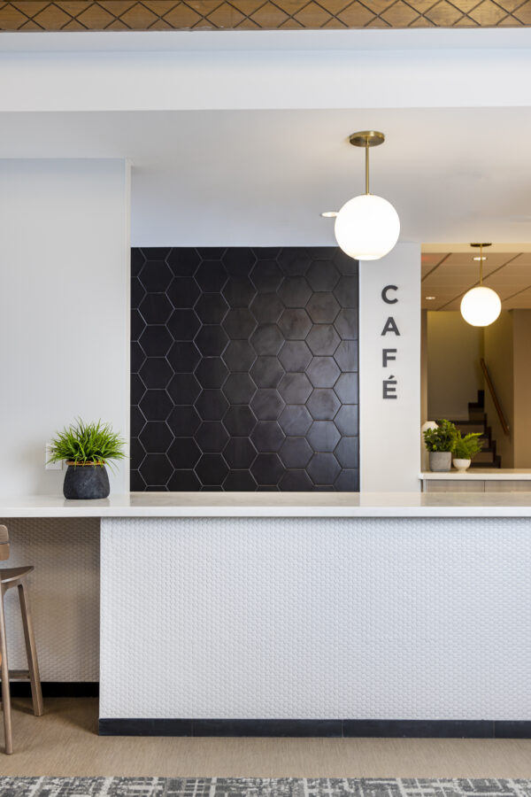Café at Fellowship Bible Church Midtown in Little Rock, Arkansas, featuring a modern counter, pendant lighting and black hexagonal tile.