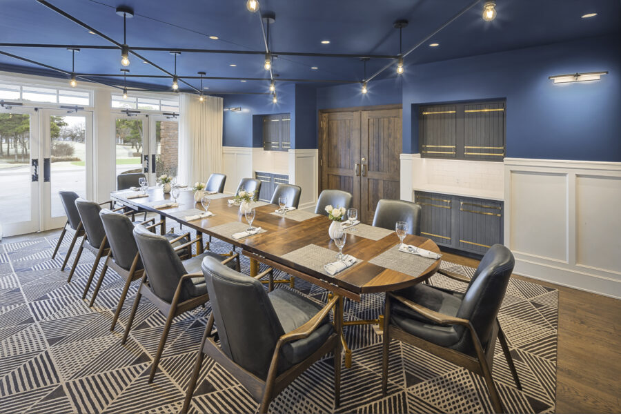 Interior view of downstairs dining room at Country Club of Little Rock, featuring dark blue ceiling and accent wall.