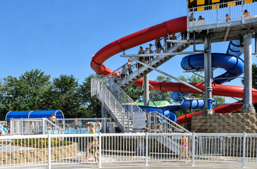 Red and blue enclosed water slides with elevated metal stairways and platforms at Springdale Aquatic Complex in Murphy Park in Springdale, Arkansas.