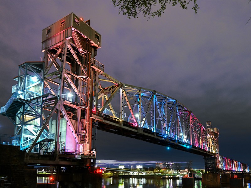 Little Rock Junction Bridge Illuminated historic Junction Bridge, designed by WDD Architectws, spanning the Arkansas River in downtown Little Rock, Arkansas, showing the steel truss structure, elevator tower and pedestrian walkway.